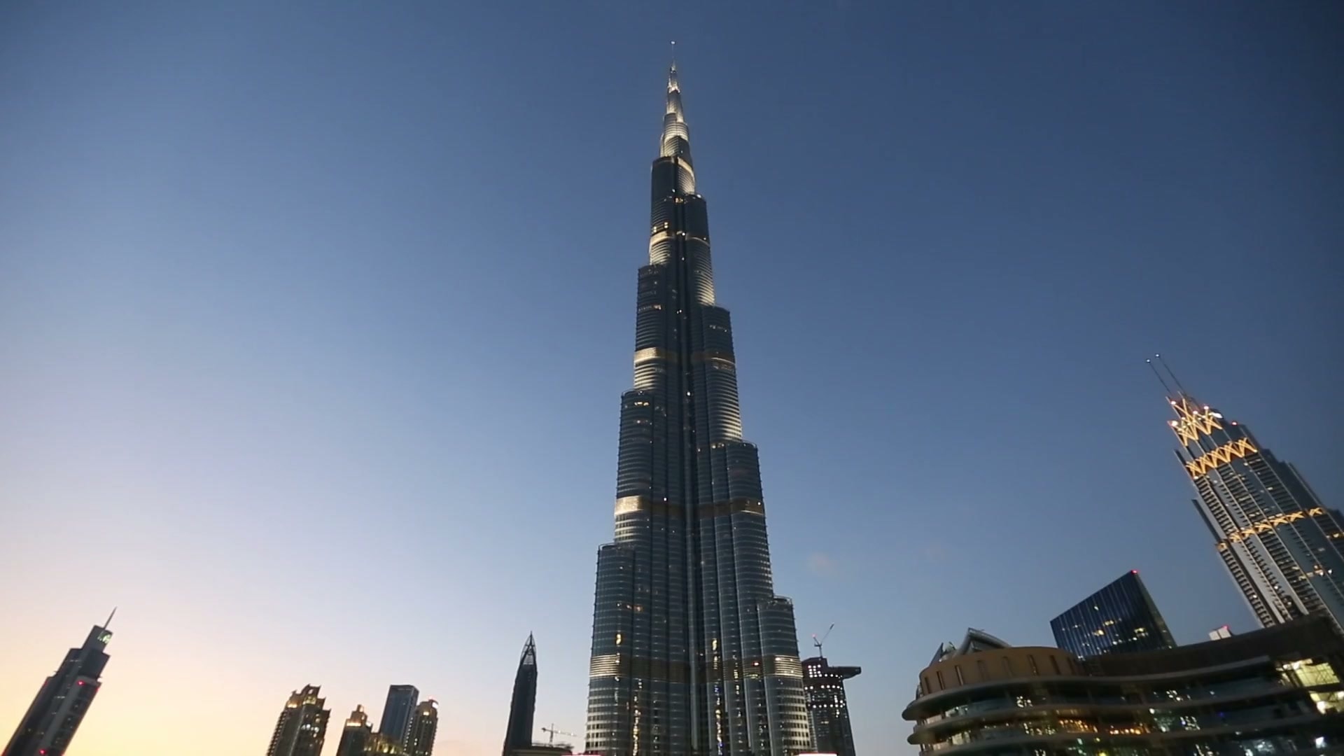The Burj Khalifa rising above Downtown Dubai at blue hour, the tower reading from the city up to its spire