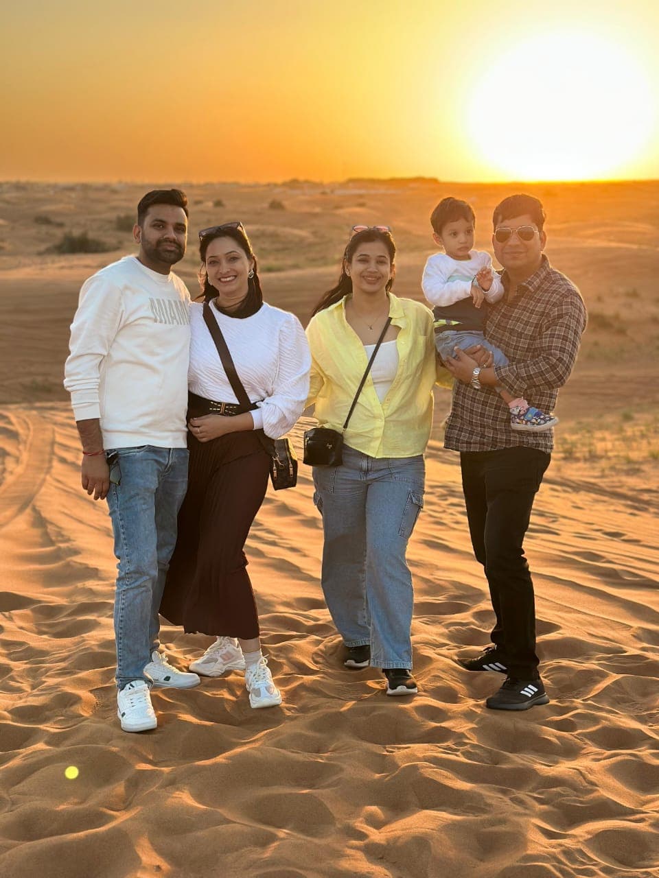 A family enjoying a desert safari at sunset