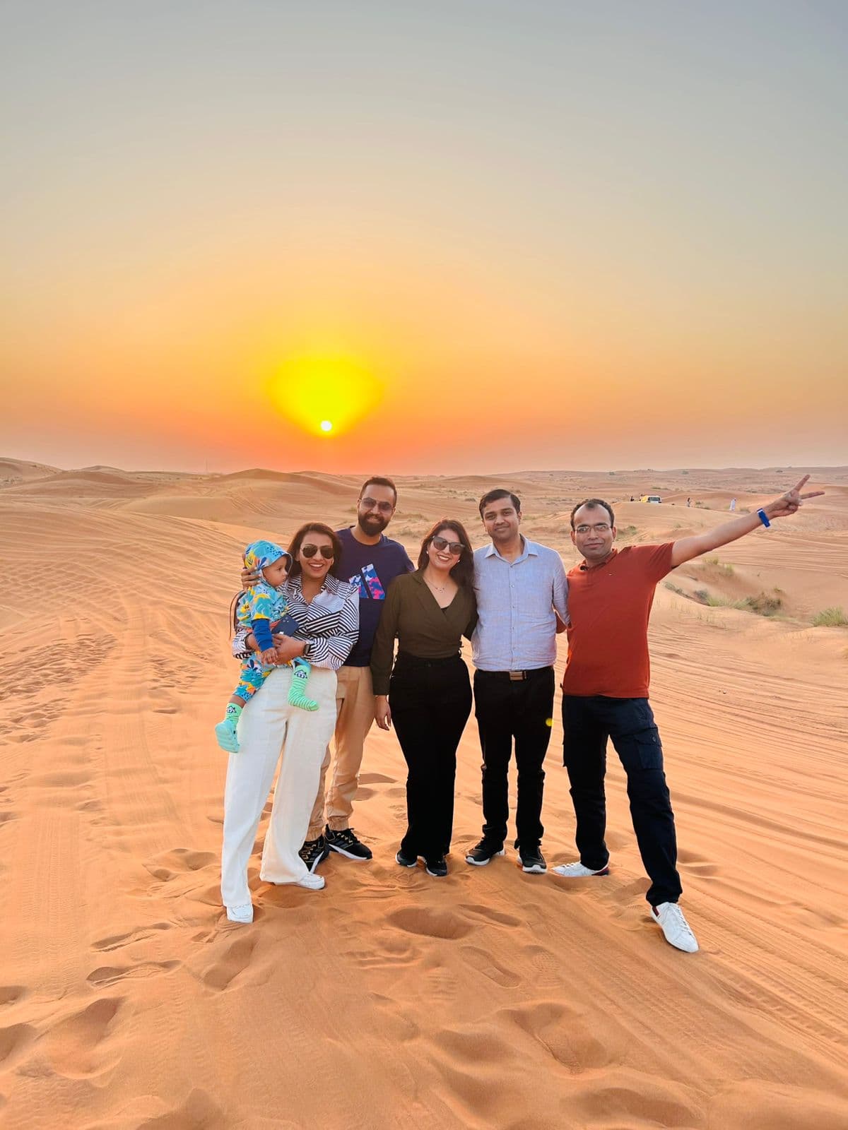 Travellers together on the dunes at sunset