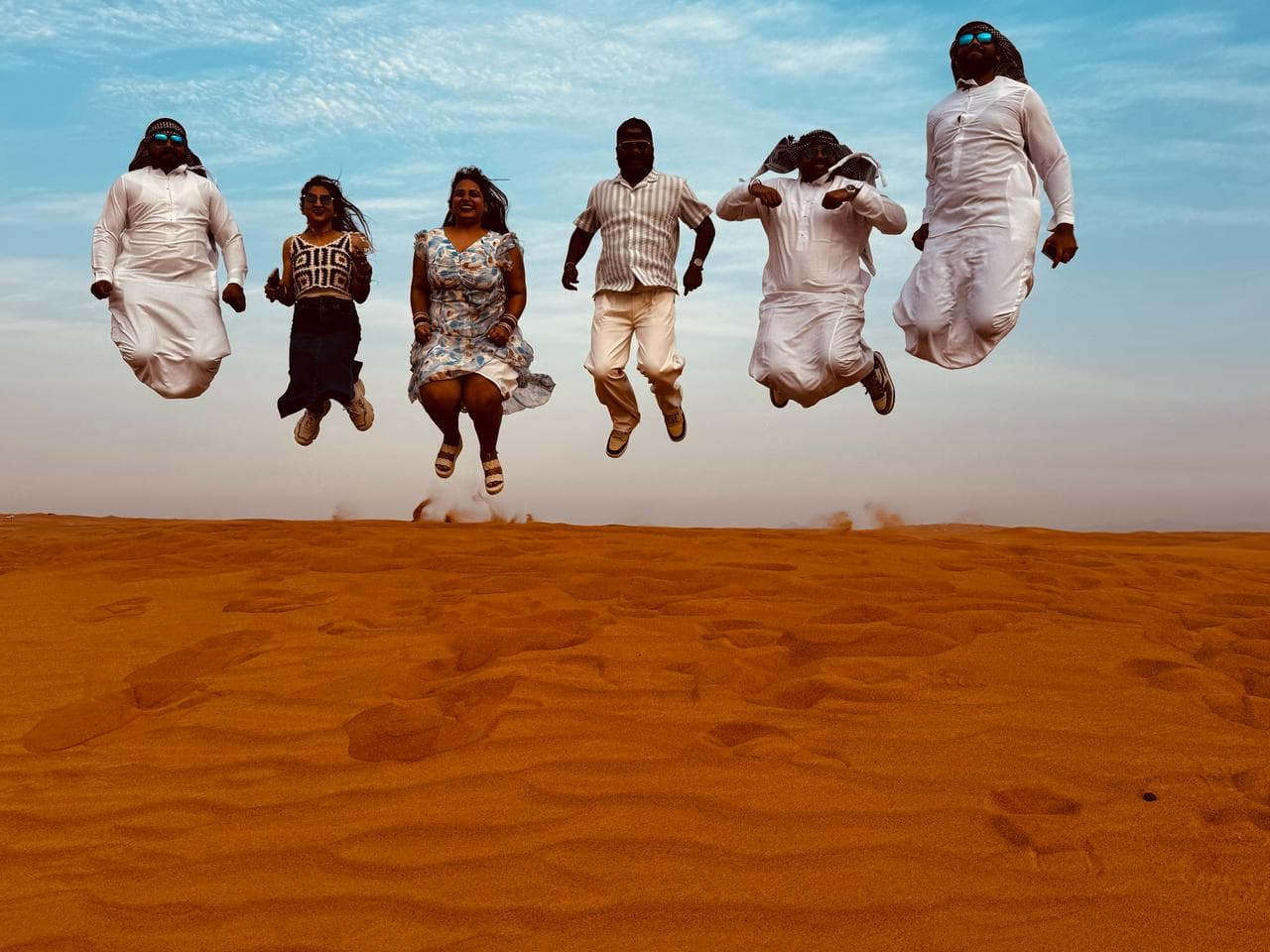 A tour group captured mid-jump on the desert dunes